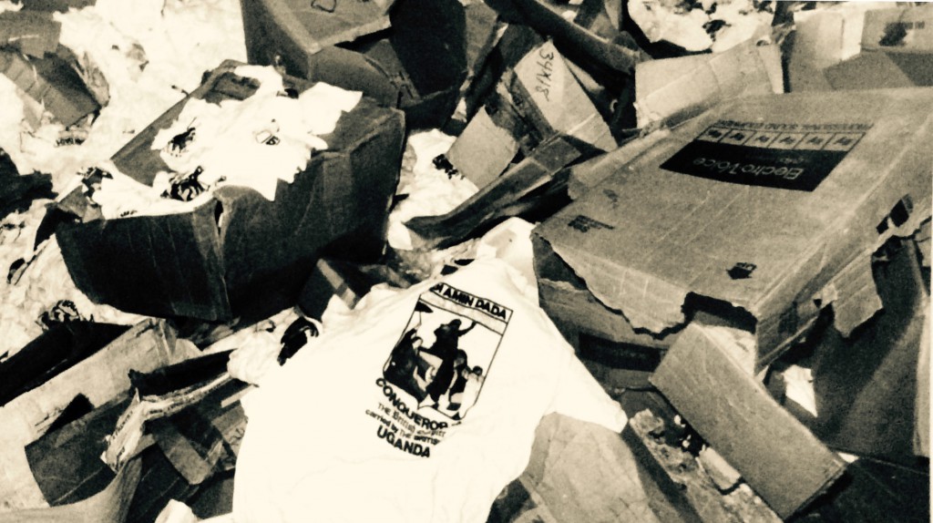 A looted storeroom at Amin's mansion. He printed hundreds of tee shirts depicting him as The Conquerer of the British Empire, taken from a photo of the occasion he forced four white businessmen to carry him in a sedan chair. One of the businessmen, car dealer Bob Scanlon, was murdered soon after the photo was taken.